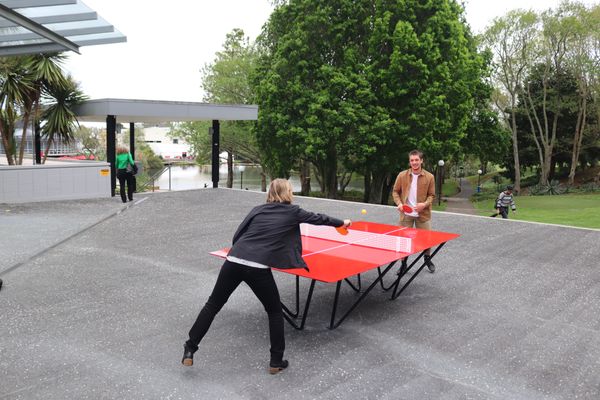 Two people playing table tennis.